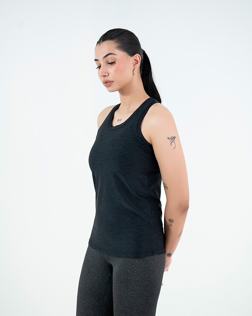 A woman modeling a black tank top and gray leggings on a white background perfect for those looking to buy womens gym wear tank top online in pakistan.